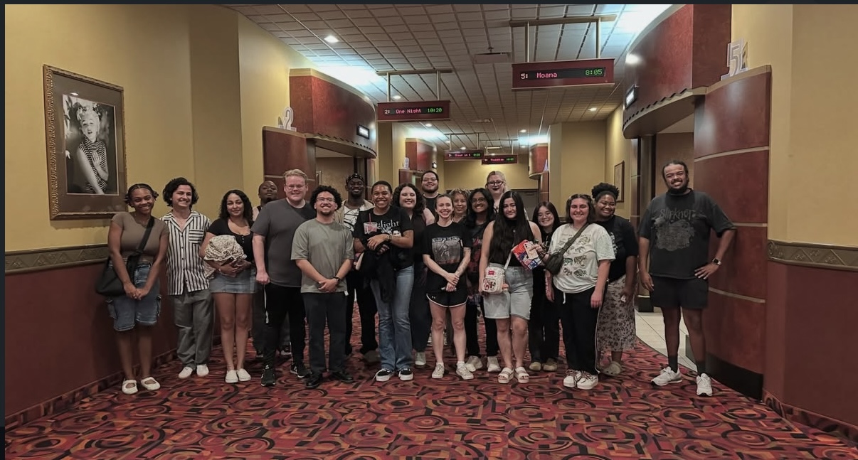 Movie club members together in a theater hallway